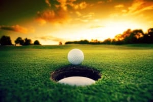Golf ball on the edge of a hole.