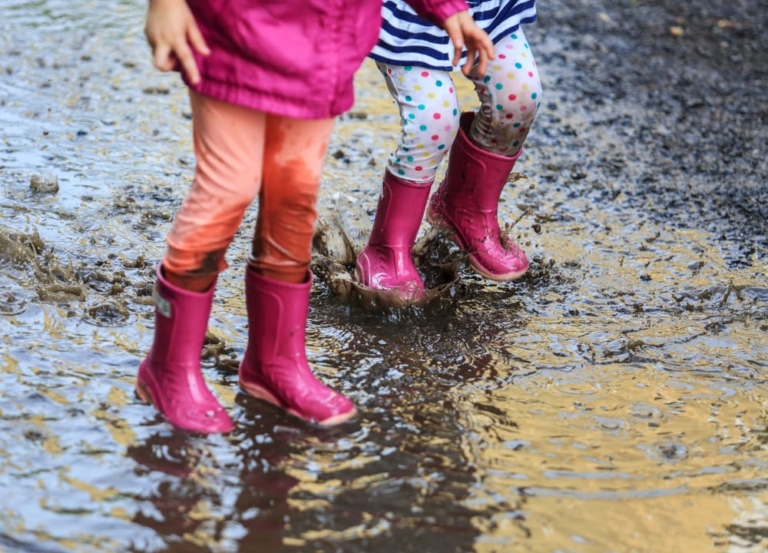 Children splashing in mud and rain.